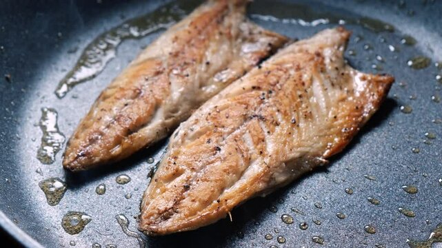 Cooking mackerel fish in a frying pan. A cook fries capelin in a restaurant kitchen before dinner. 