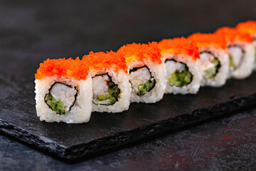 Japanese sushi, rolls with shrimp and caviar on a black background