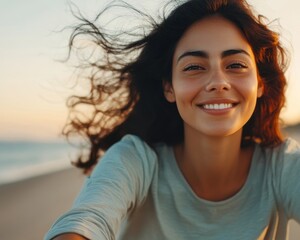 Close-up of a Hispanic woman riding a bicycle along a coastal road, her hair flowing in the wind, with the ocean in background. Freedom, joy, and beauty of outdoor adventure on a sunny day by the sea.
