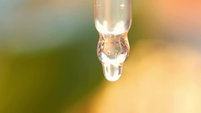 Closeup of the dropper with orange cosmetic oil. 