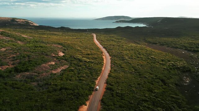 aerial shot over hellfire road in Cape Legrand National Park following a van driving on a dirt road to hellfire bay on a cloudy day in Western Australia