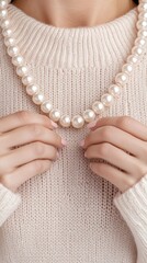 Delicate hands in knit sweater carefully placing pearls on a beautiful necklace with gigapixel clarity