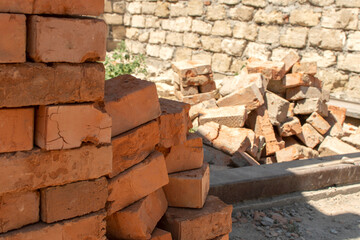 Pile of a bricks against brick wall	