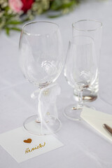 Wedding table with detail of glasses, cutlery and signs with name tags in the Czech language