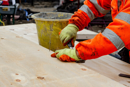 Craftsman carpenter skillfully using tools to shape wood during construction on a bright afternoon