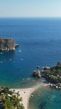 Il mare e la spiaggia di Isola Bella a Taormina, Sicilia, sud Italia.
Ripresa aerea della baia di Taormina con l'Isola Bella collegata alla terra ferma tramite un istmo di terra.