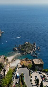 Il mare e la spiaggia di Isola Bella a Taormina, Sicilia, sud Italia.
Ripresa aerea della baia di Taormina con l'Isola Bella collegata alla terra ferma tramite un istmo di terra.