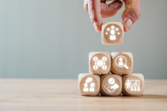 Wooden blocks with career transition icons symbolize outplacement services for employee support and professional growth.