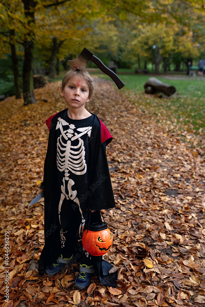 Poster Boy in a forest with Halloween costumes, carved pumpkins with candles and decoration, creepy concept