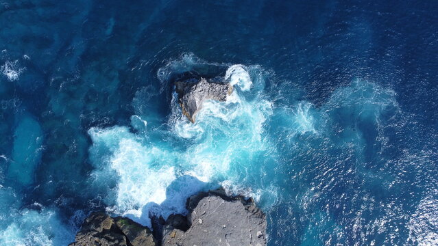 Drone photo of waves crashing onto the coastline 