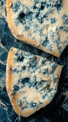 Delicious blue cheese slices are displayed on a dark marble surface, perfect for a gourmet dinner or cheese tasting event with friends