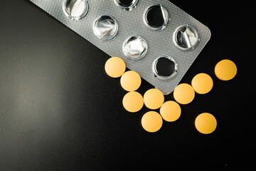 Pills Medicine tablet Brown Yellow in blister pack on a black background