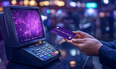 A hand holding a card near a payment terminal with a digital display. - Powered by Adobe