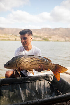 Young boy showing off a carp he just caught