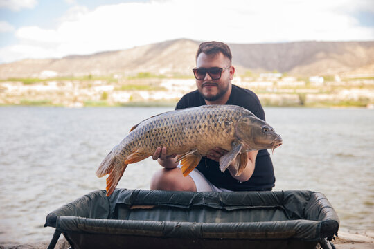 Young boy showing off a carp he just caught