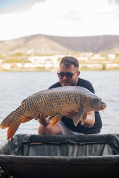 Young boy showing off a carp he just caught
