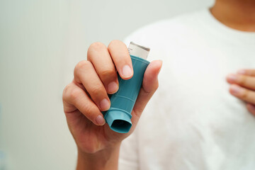 Asthma and chronic obstructive pulmonary disease COPD, Asian young man using metered dose inhaler...