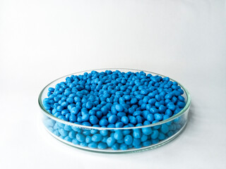 Blue masterbacth granules, pigment resin coloring, flowing like rain, collected in glass cup,...