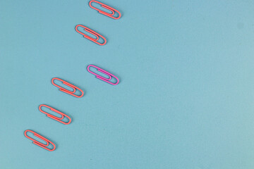 Beautiful pastel colors of paper clips on isolated blue background. 
Background concept.