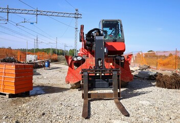 Rotating telehandler with forklift attachment during railroad  maintenance work. Front view.