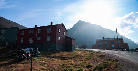 Fototapeta premium Exploring the scenic landscape of Longyearbyen with red buildings and majestic mountains