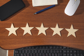 Wooden 5 stars on the workplace. Customer satisfaction
