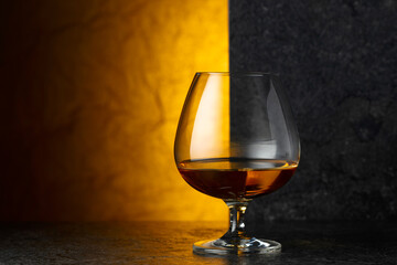 Glass of brandy on a black table.