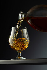 Cognac or brandy being poured into a glass.
