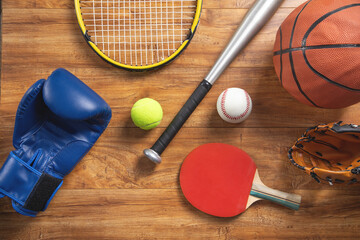 Various sport equipments on wooden background.