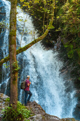A man with his back turned at the impressive Xorroxin waterfall in northern Navarra