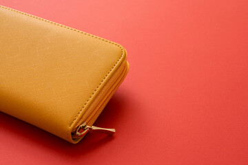 Yellow wallet on a red background.  Japanese Wallets for financial luck  赤背景上の黄色の財布。金運アップに用いられる日本の財布。