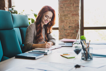 Photo of smiling positive lady boss formalwear working writing notebook indoors workplace...