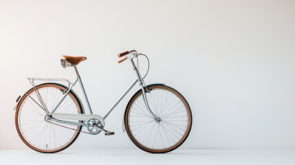 A classic, powder blue bicycle with brown leather seat and tires against a white wall.