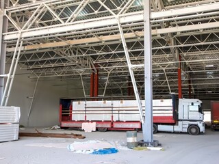 Naklejka premium Truck loaded with building materials inside an industrial construction site warehouse.