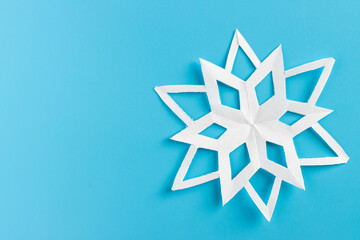 white paper cut out snowflakes in light blue background. Empty space for copy space. winter or christmas theme background. selective focus.