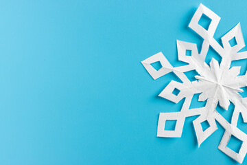 white paper cut out snowflakes in light blue background. Empty space for copy space. winter or christmas theme background. selective focus.