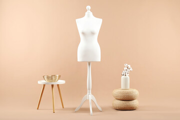 Female mannequin and vase on beige background