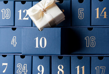 Advent calendar, blue boxes with numbers with gift, closeup. Waiting, Christmas countdown.