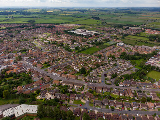 Obraz premium Aerial photo of the UK town of York in North Yorkshire England showing rows of houses and streets along side roads on the typical British housing estates on a partly cloudy summers day