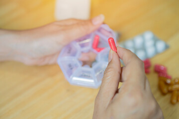 Female hands sorting pills. Young woman getting her daily vitamins at home.