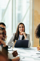 Confident female professional leading a vibrant marketing group discussion in a modern office...