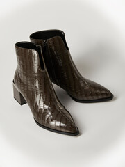 women's shoes with imitation crocodile skin on a light background