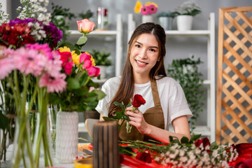 Fototapeta premium Portrait of florist woman completing beautiful bouquet in flower shop. 