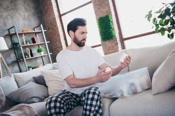 Photo of handsome young guy confused choose pills medicament dressed nightwear wake up spacious...