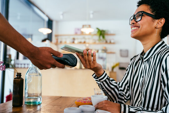 Bakery, happy portrait of black woman in cafe ready for serving pastry, coffee and baked foods. Restaurant, coffee shop and confident waiter barista by counter for service, help and welcome