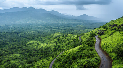 Lush green mountains with misty horizon and winding road create serene landscape. vibrant greenery and rolling hills evoke sense of tranquility and adventure