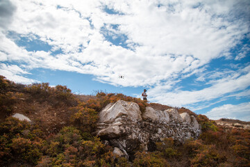 person on top of mountain flying fpv drone, Peniche, Portugal