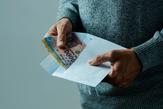 man takes out or puts some forints into an envelope