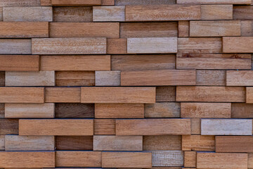 image of a wall covered in wood tiles of various sizes. wooden background texture concept.