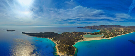 Capo Carbonara’s rocky shores, sandy Porto Giunco beach, Torre di Porto Giunco, and yachts in the calm Tyrrhenian Sea.